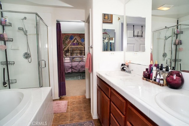 bathroom with tile patterned flooring, independent shower and bath, and vanity