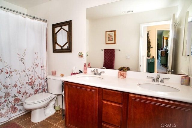 bathroom with tile patterned flooring, vanity, and toilet