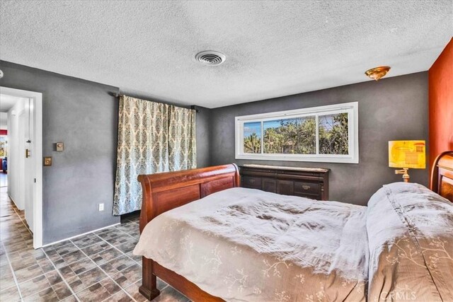 bedroom featuring visible vents and a textured ceiling