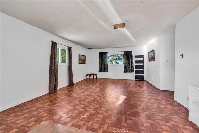 unfurnished room with a wealth of natural light and baseboards