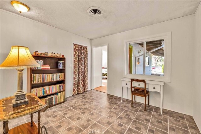 living area with visible vents and a textured ceiling