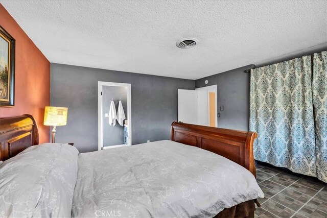 bedroom featuring visible vents and a textured ceiling