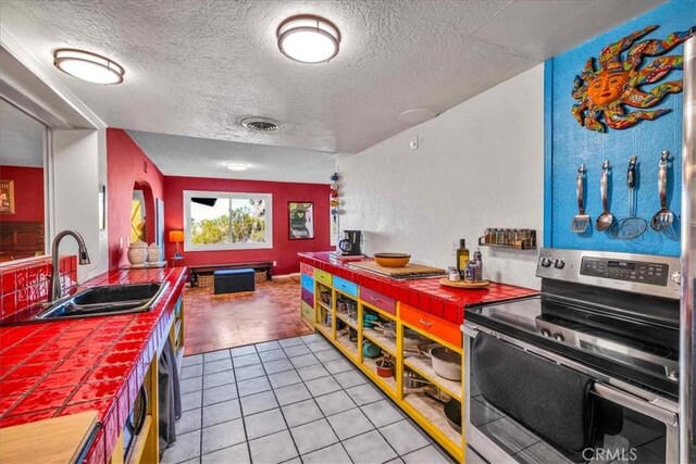 game room with light tile patterned floors, visible vents, a textured ceiling, and a sink