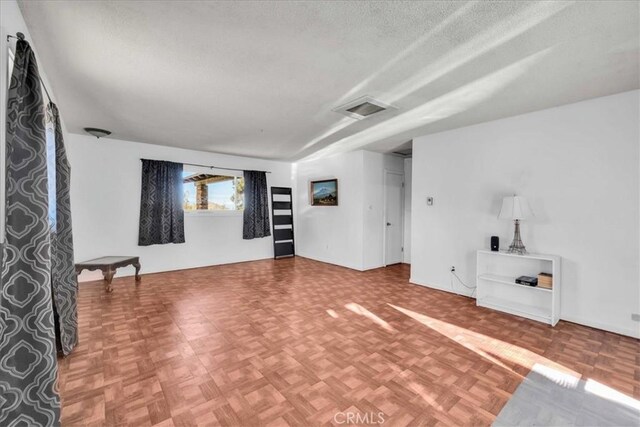 unfurnished living room with visible vents and a textured ceiling