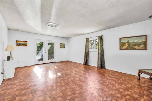 interior space with french doors and a textured ceiling