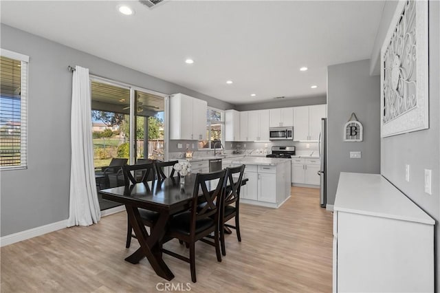 dining room featuring sink, plenty of natural light, and light hardwood / wood-style flooring