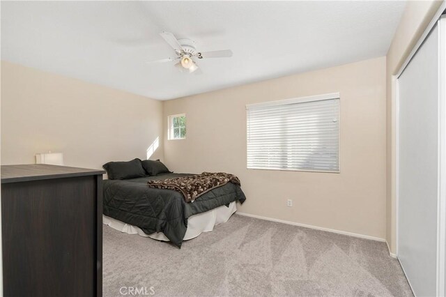 carpeted bedroom with ceiling fan and a closet