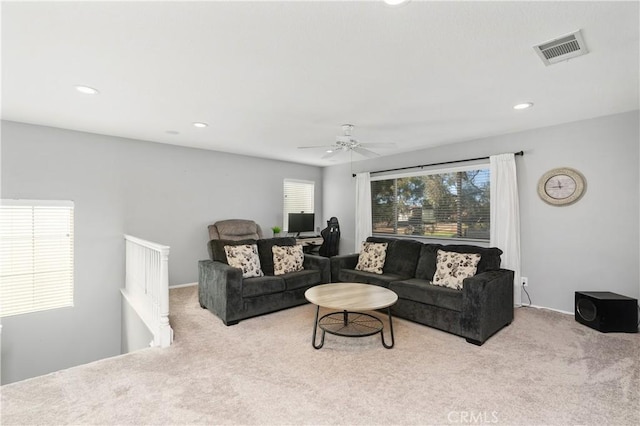 carpeted living room with ceiling fan and plenty of natural light