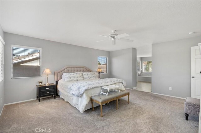 bedroom with connected bathroom, ceiling fan, and light colored carpet