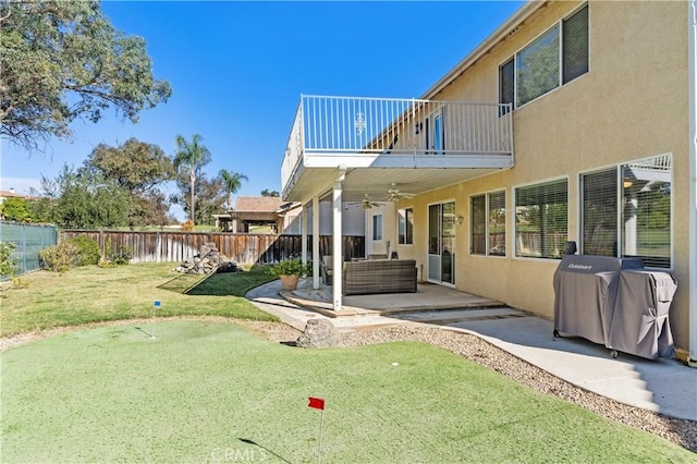 view of yard featuring a patio area, a balcony, ceiling fan, and an outdoor living space