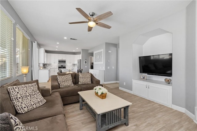 living room with sink, ceiling fan, and light hardwood / wood-style floors