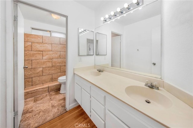 bathroom with toilet, vanity, and hardwood / wood-style flooring