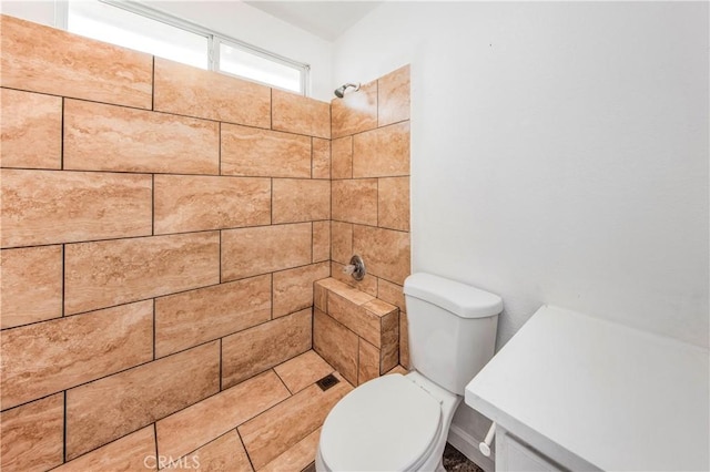 bathroom with toilet and a tile shower