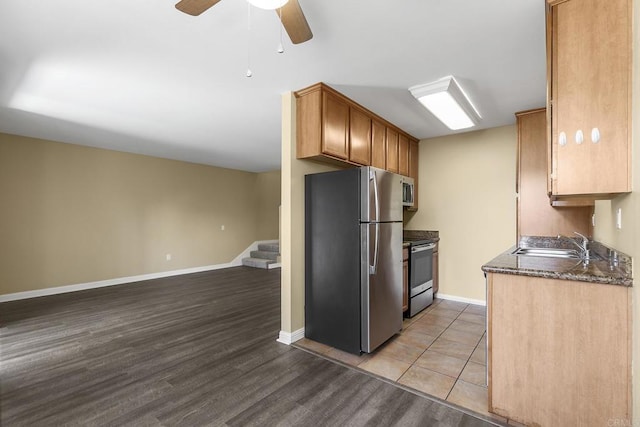 kitchen featuring sink, light wood-type flooring, ceiling fan, and appliances with stainless steel finishes