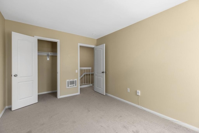 unfurnished bedroom with light carpet and a closet