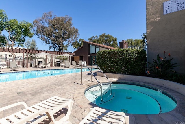 view of swimming pool with a community hot tub and a patio