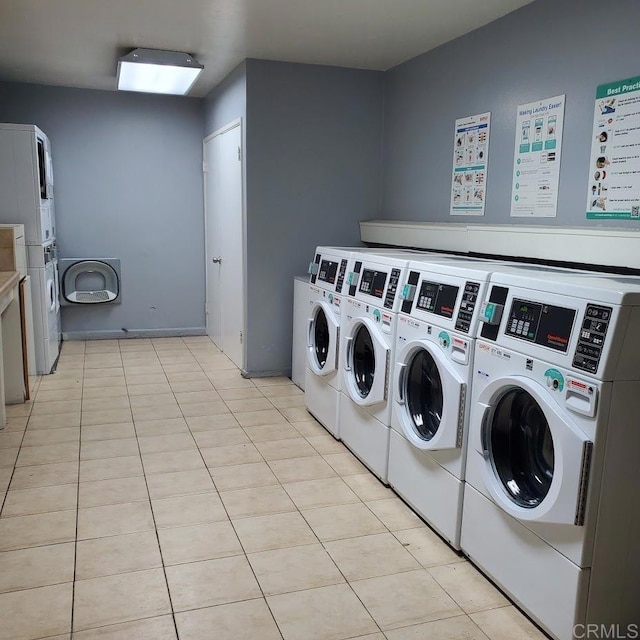 clothes washing area featuring stacked washing maching and dryer, washer and dryer, and light tile patterned flooring