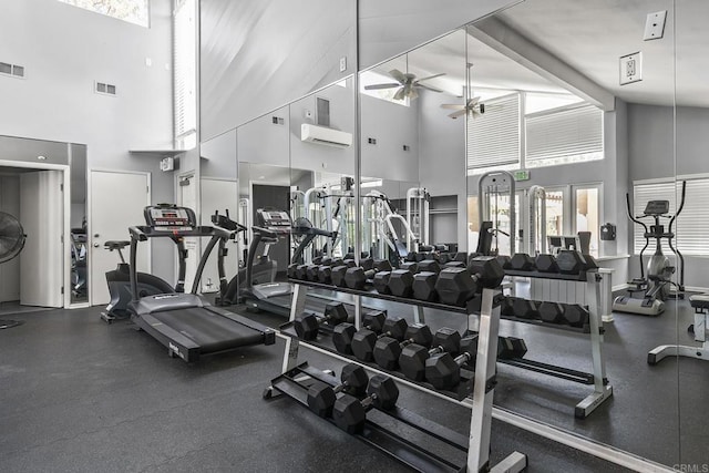 exercise room featuring lofted ceiling, a wall unit AC, and ceiling fan