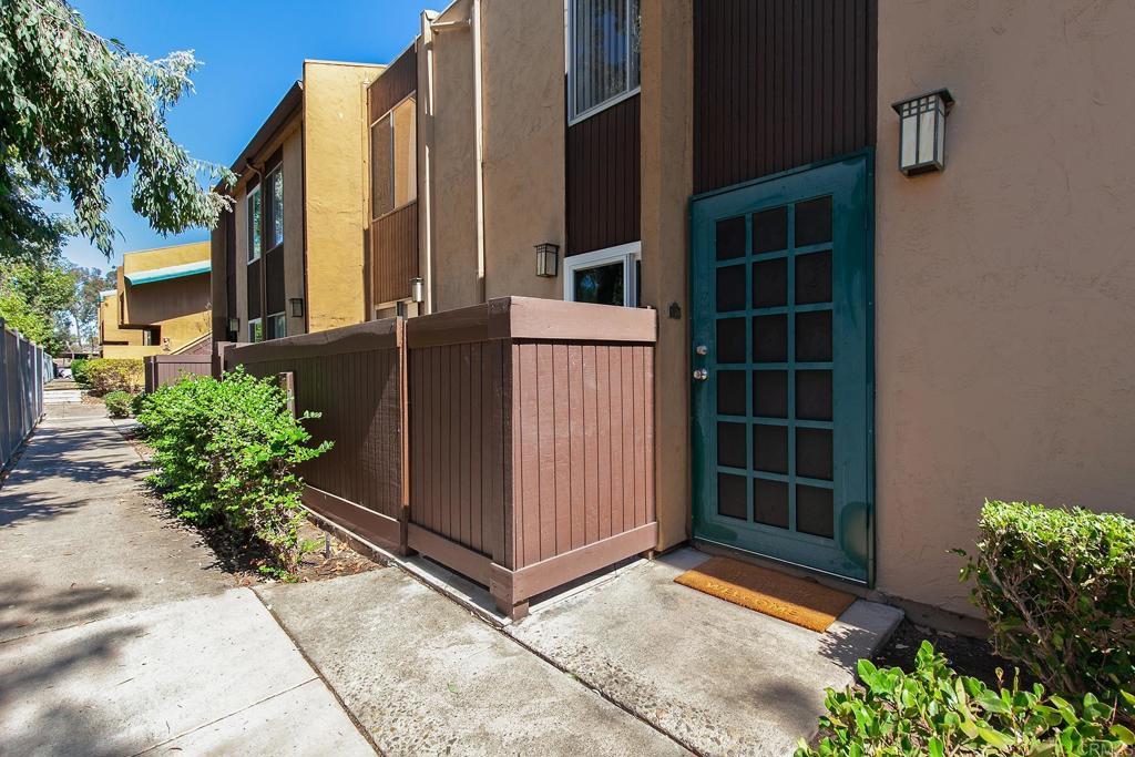 view of exterior entry with fence and stucco siding