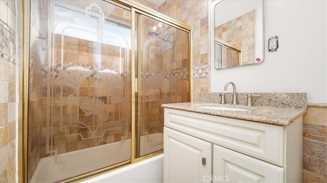 bathroom with vanity and enclosed tub / shower combo