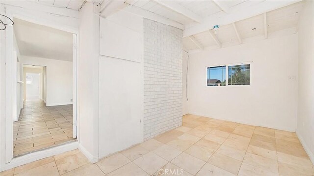 unfurnished room with vaulted ceiling with beams and wooden ceiling