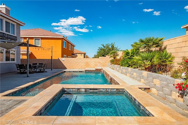 view of pool with a patio, an in ground hot tub, and pool water feature