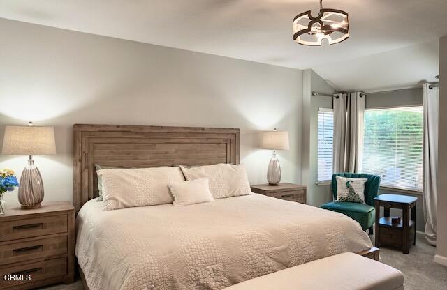 carpeted bedroom with vaulted ceiling