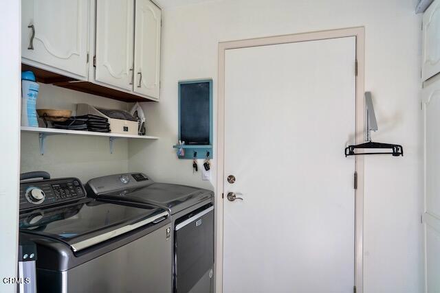 washroom featuring cabinets and washing machine and clothes dryer