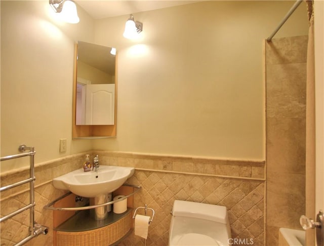 full bathroom with sink, washtub / shower combination, tile walls, and toilet