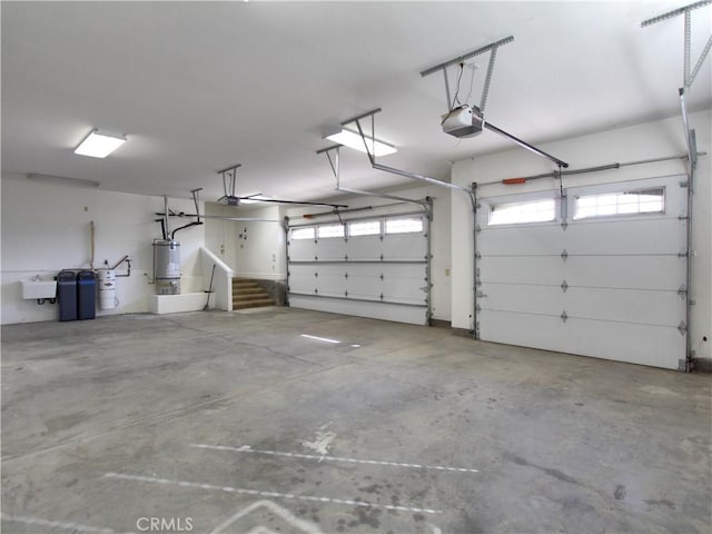 garage with sink, a garage door opener, and water heater