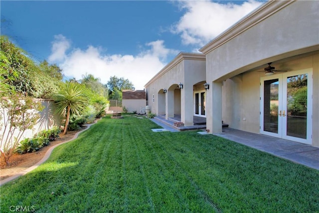 view of yard featuring french doors, ceiling fan, and a patio area