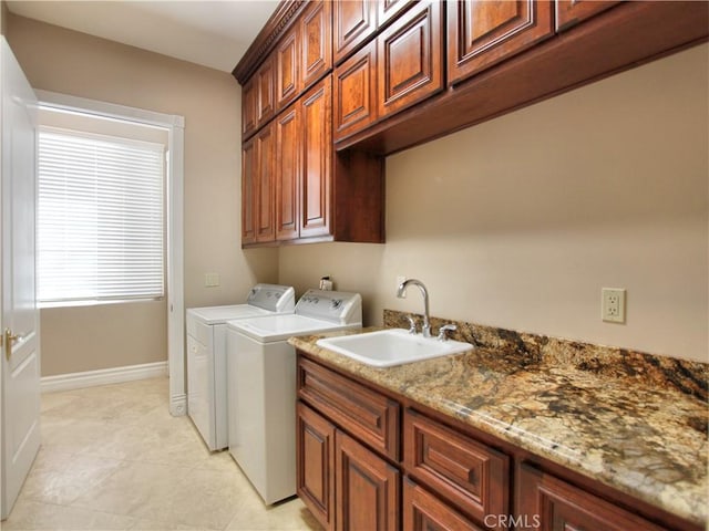 clothes washing area with cabinets, separate washer and dryer, and sink