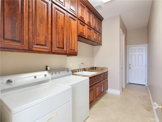 laundry room with cabinets, washing machine and dryer, and sink