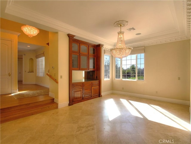 interior space featuring a tray ceiling, crown molding, and an inviting chandelier