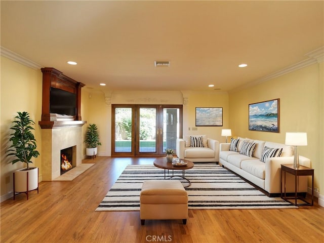 living room with light hardwood / wood-style floors and crown molding