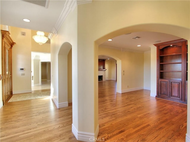 hallway featuring light hardwood / wood-style flooring and ornamental molding