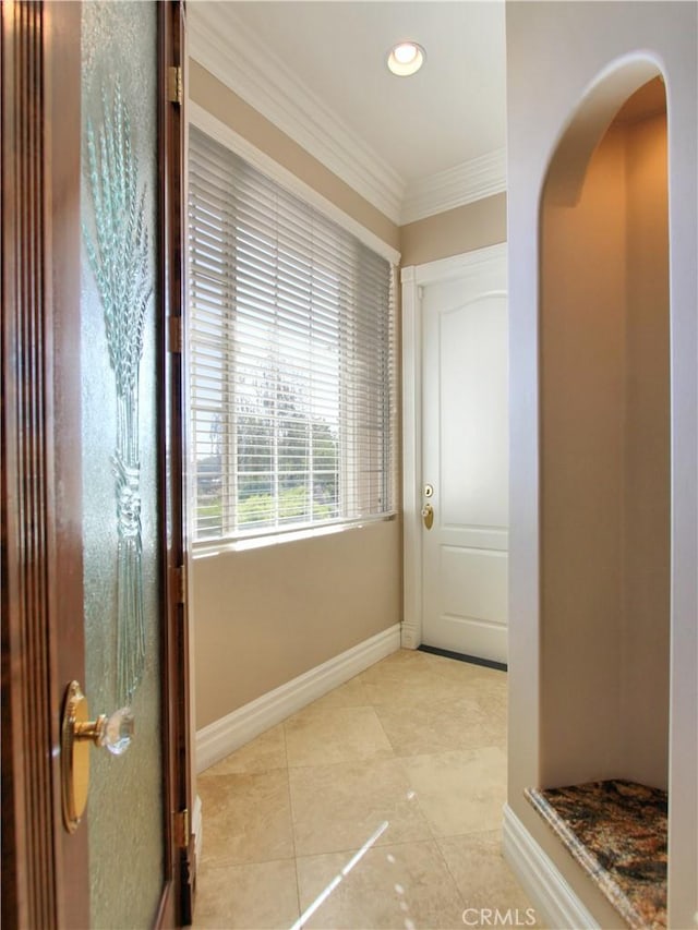 doorway to outside with light tile patterned flooring and ornamental molding