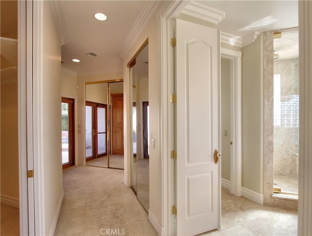 hallway with light colored carpet and ornamental molding