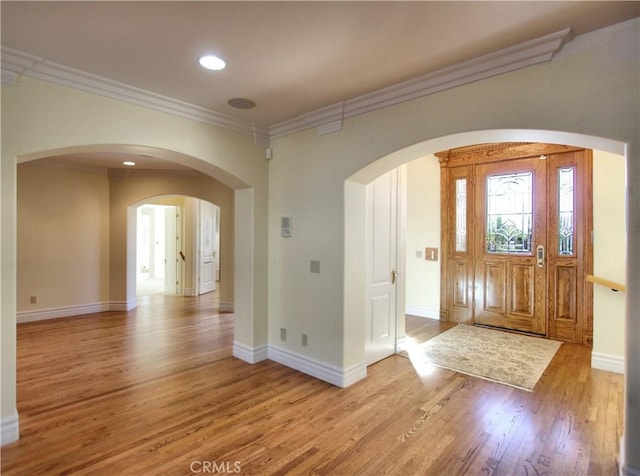 entryway with light wood-type flooring and crown molding