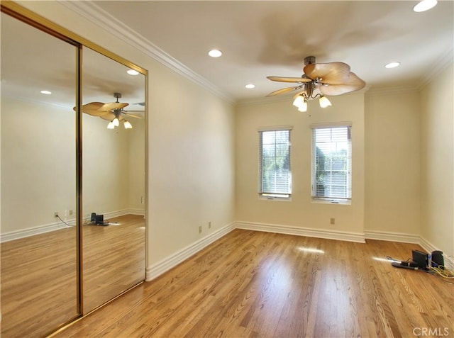 empty room featuring light hardwood / wood-style floors, ceiling fan, and crown molding