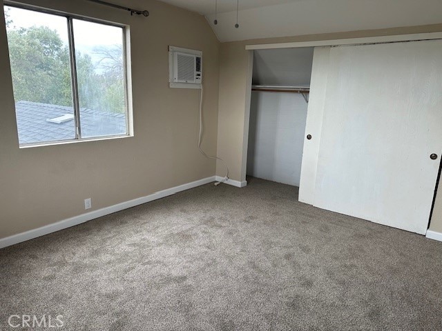 unfurnished bedroom with a closet, vaulted ceiling, and carpet flooring