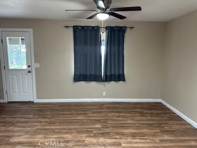 unfurnished room with dark wood-type flooring and ceiling fan