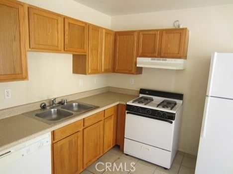 kitchen with light tile patterned flooring, white appliances, and sink