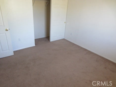 unfurnished bedroom featuring a closet and carpet