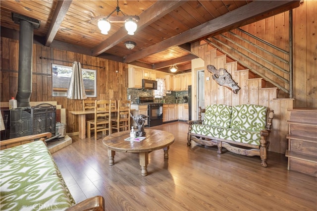 living room with a wood stove, wood walls, wood ceiling, and light hardwood / wood-style floors