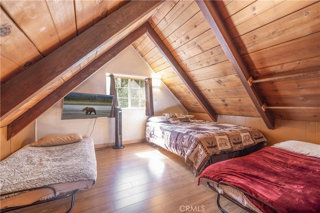 bedroom with wooden walls, vaulted ceiling with beams, wood ceiling, and light hardwood / wood-style floors