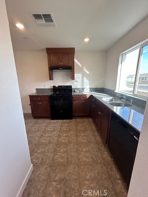 kitchen with dark tile patterned floors, sink, kitchen peninsula, and black appliances