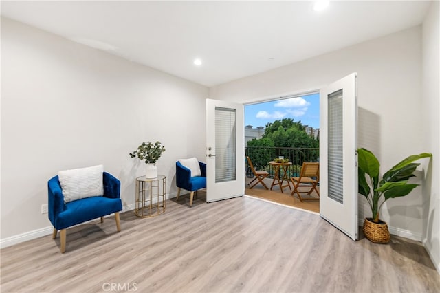 living area featuring french doors and light hardwood / wood-style floors