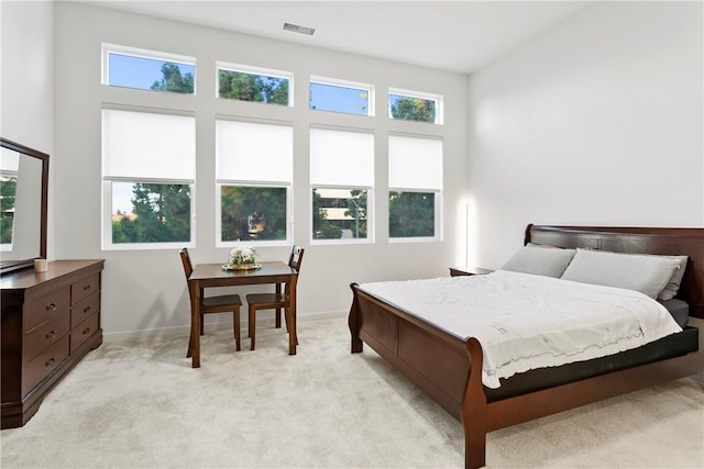 bedroom featuring light carpet and a high ceiling