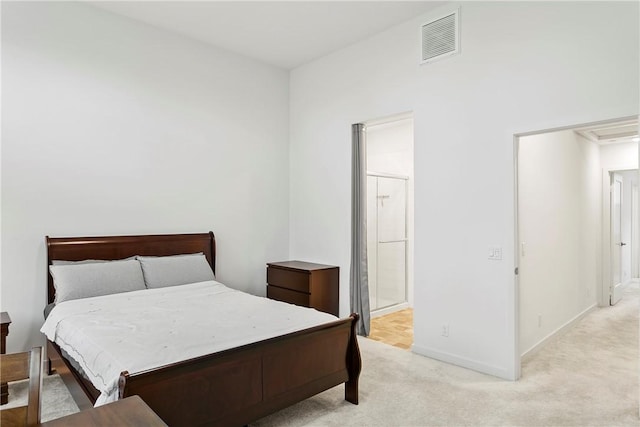 bedroom featuring light carpet and ensuite bathroom